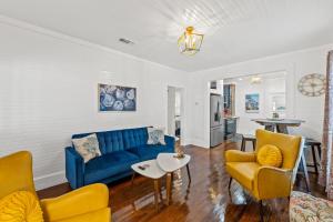 a living room with a blue couch and yellow chairs at Mystic Moon- family friendly fenced yard pets welcome in Port Saint Joe