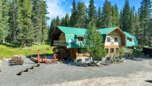 诺德格HI Nordegg - Hostel的带有绿色屋顶和停车场的小木屋