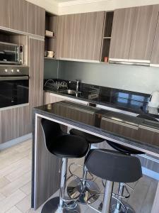 a kitchen with two bar stools at a counter at Departamento en centro de Viña del Mar in Viña del Mar