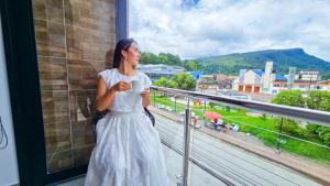 a woman in a white dress looking out a window at Hotel VILLA CABAÑA in Villagarzón