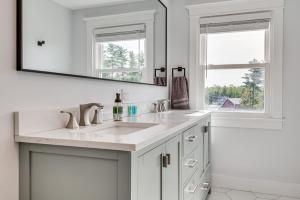 a white bathroom with a sink and a mirror at Golf, Hike and Explore Family Home in Pembroke! in Bow Center +32 photos