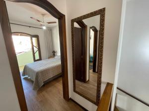specchio in camera con letto di Cód 9 · Casa aconchegante á 300m do mar! a Governador Celso Ramos