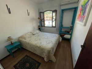 una piccola camera da letto con un letto e una finestra di Cód 9 · Casa aconchegante á 300m do mar! a Governador Celso Ramos