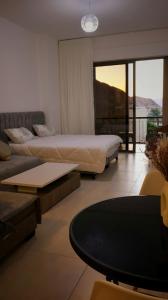 a bedroom with two beds and a couch and a table at قرية الراحة باطلالة بحرية-مرسى زايد-Alraha village -marsa zayed- with sea view in Aqaba