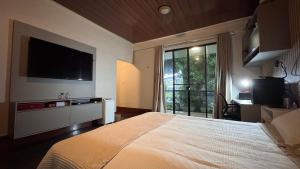 a bedroom with a large bed with a television on the wall at Casa Cristalville in Água Boa