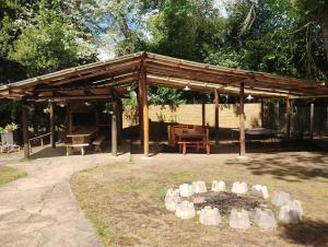 a wooden pavilion with a fire place in a park at Quinta Pehuen in Tortuguitas