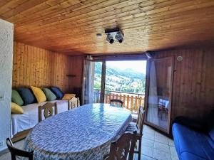 a room with a table and a bed and a balcony at Le Balcon d'Aillon in Aillon-le-Jeune