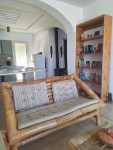 a wooden bench in a room with a kitchen at Petite villa- Tamezrat- Kelibia in Kelibia