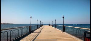 a wooden pier with lights on the water at Private Apartment One bed room at Talabay -Independent Listing in Aqaba