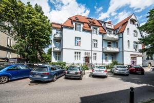 un groupe de voitures garées devant un bâtiment dans l'établissement Sea Apartments AG, à Sopot