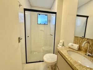 a bathroom with a shower and a toilet and a sink at Achei Itapema • Perequê em grande estilo, 2 suítes in Perequê +8 photos