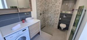 a bathroom with a washing machine and a shower at Escapade Pau Appart moderne avec terrasse privée in Pau +7 photos