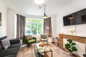 ein Wohnzimmer mit Couch und Kamin in der Unterkunft KGV Stays - Serenity House 3 bedroom near to the hospital with parking in Southampton