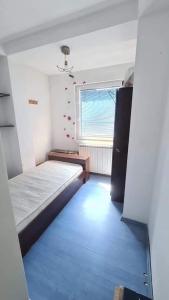a small room with a bed and a window at Spacious and Bright 2BR Apartment near City Center in Skopje