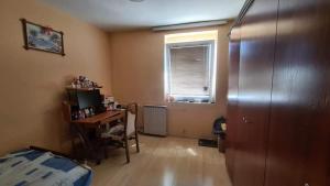 a room with a desk and a computer and a window at Spacious and Bright 2BR Apartment near City Center in Skopje
