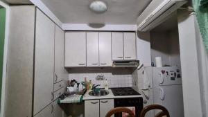 a kitchen with white cabinets and a stove and a refrigerator at Spacious and Bright 2BR Apartment near City Center in Skopje +5 photos