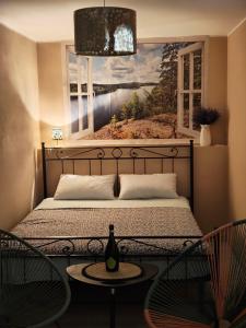 a bedroom with a bed and two chairs and a window at Appartamento con sauna e home cinema in Colonno