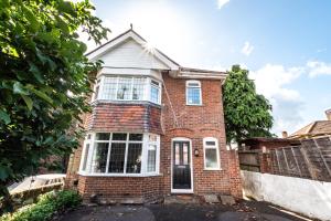 ein rotes Backsteinhaus mit einem weißen Fenster in der Unterkunft KGV Stays - Serenity House 3 bedroom near to the hospital with parking in Southampton