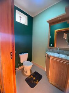 une salle de bain avec toilettes et lavabo dans l'établissement Duas Suites aconchegantes em frente a Montanha, à Poços de Caldas