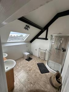 a attic bathroom with a shower and a sink at The Church M in Manchester