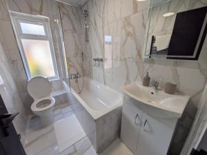 a bathroom with a toilet and a sink and a shower at Modern Central Apartments with Balcony in Wellingborough +67 photos
