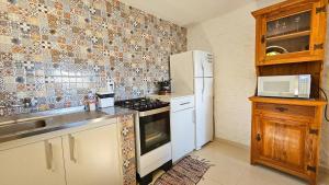 a kitchen with a stove and a white refrigerator at Chalés Mirante Monte Verde in Monte Verde