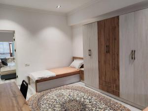 a small room with two beds and a cabinet at Snowlight Studio in Toshkent-Passajir Bekati