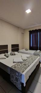 two beds in a room with twothirdsessionsyss at Apto no coração de Serra Negra in Serra Negra