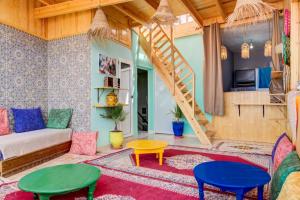 a living room with colorful furniture and a staircase at imsouane bleu bay house in Imsouane