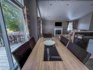 a dining room with a wooden table and chairs at Stunning Lodge With Decking At Oaklands Holiday Park In Essex Ref 39017Rw in Clacton-on-Sea
