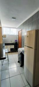 a kitchen with a refrigerator in the middle of a room at Apto no coração de Serra Negra in Serra Negra