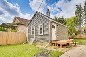 a small house with a bench in the yard at 3 Mi to Michigan State Tiny Home with Deck! in Lansing
