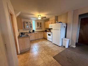 a kitchen with a white refrigerator and a sink at Unique Southwest 2-bedroom home Permit #03015 in Alamosa