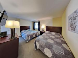 a hotel room with two beds and a television at Put-in-Bay Poolview Condo #3 in Put-in-Bay +12 photos