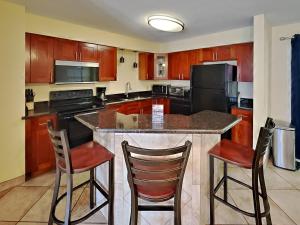 a kitchen with a large island with two bar stools at Put-in-Bay Poolview Condo #3 in Put-in-Bay