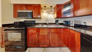 a kitchen with wooden cabinets and a sink at Put-in-Bay Poolview Condo #3 in Put-in-Bay