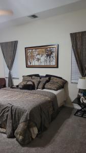 a bedroom with a large bed and a picture on the wall at Elegant Hideaway with Heated Pool, Spa & Reclining Bliss in Valrico