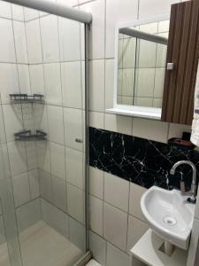 a bathroom with a shower and a sink and a mirror at Suíte de Lane e Mú 2 in Abraão