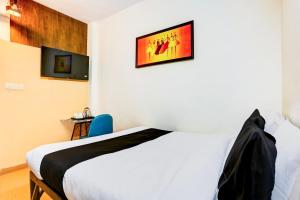 新德里Super Hotel O KC的一间卧室，墙上有一张床和一台电视