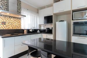 a kitchen with white cabinets and a black counter top at Tatuapé , garagem e ar condicionado in Sao Paulo