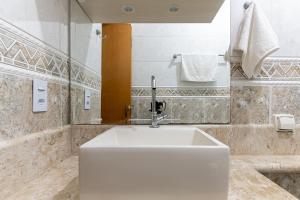 a bathroom with a white sink and a mirror at Tatuapé , garagem e ar condicionado in Sao Paulo +25 photos