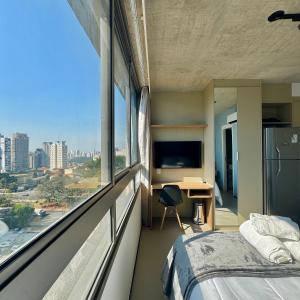 a bedroom with a bed and a desk and a window at Studios Prime - On Domingos, próx. ao Metro Vila Mariana in Sao Paulo