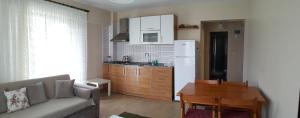 a living room with a couch and a table and a kitchen at Suna Apart Hotel in Gokceada Town