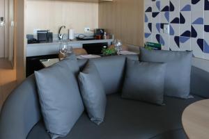 een woonkamer met een bank met kussens en een tafel bij Flat melhor localização Hotel Athos Bulcão in Brasilia