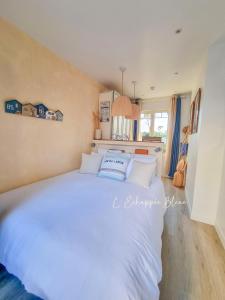 a bedroom with a large white bed with white pillows at L'Échappée Bleue, maison à 200m de la mer pour vacances et travail in Saint-Brevin-les-Pins