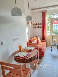 a living room with a table and a couch at L'Échappée Bleue, maison à 200m de la mer pour vacances et travail in Saint-Brevin-les-Pins