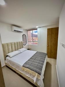 a bedroom with a large bed and a window at paraiso 1909 apto en el centro Cali in Cali