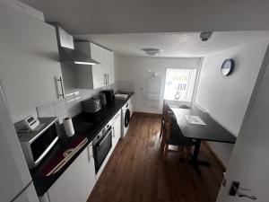 a kitchen with a counter and a table in it at Cottage style flat in Oswaldtwistle +6 photos