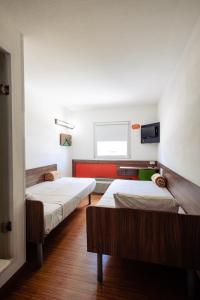 a room with two beds and a tv on the wall at Hotel Hi! Zapopan in Guadalajara