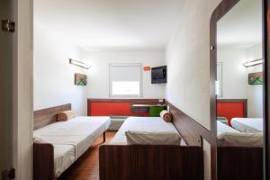 a room with two beds and a tv at Hotel Hi! Zapopan in Guadalajara